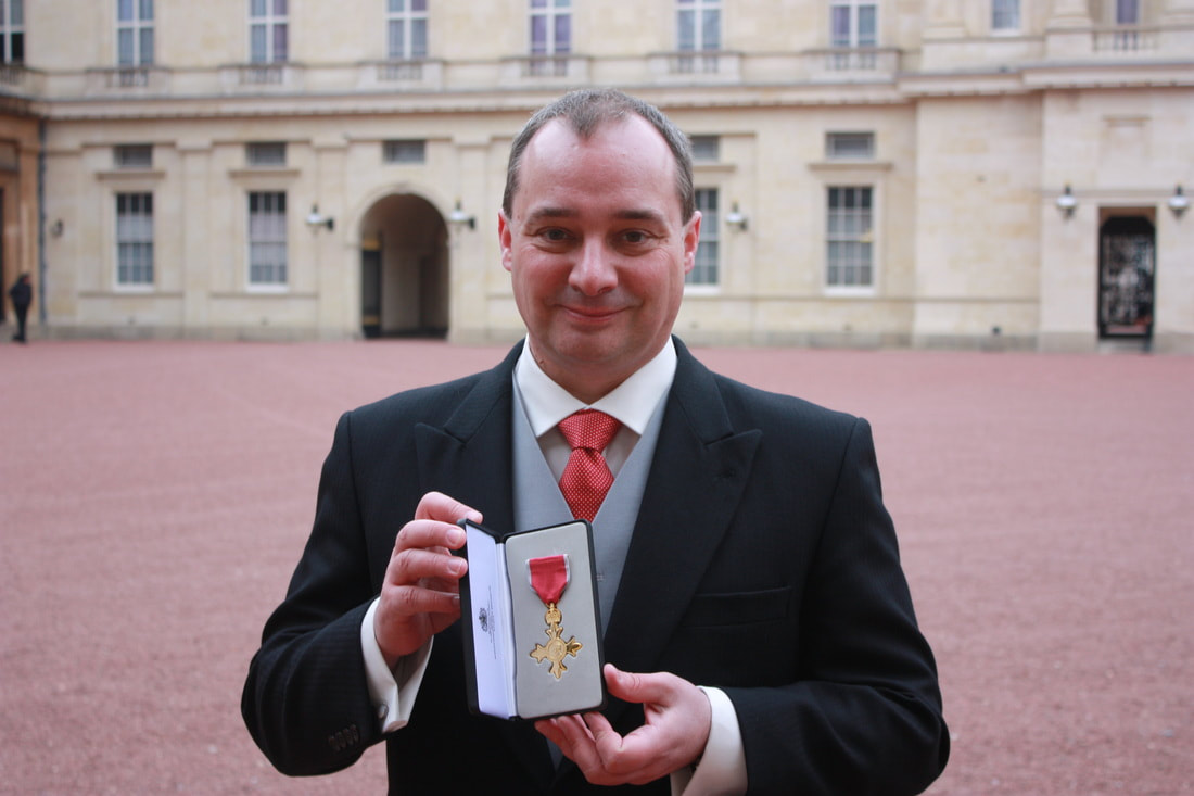 Professor Richard Wilding with his OBE medal at Buckingham Palace.